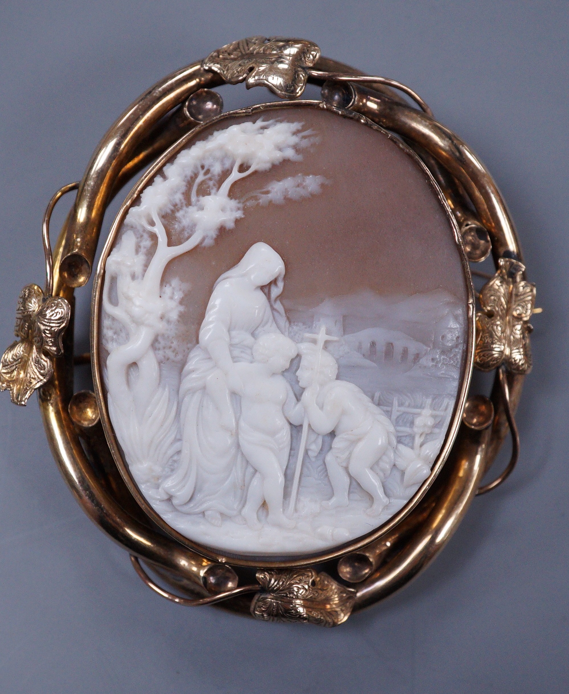 A Victorian yellow metal mounted oval cameo shell brooch, carved with Madonna and child with a young St. John, 70mm